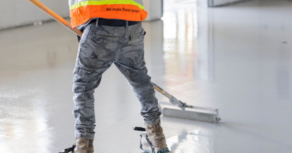 backside view of worker applying concrete sealant 